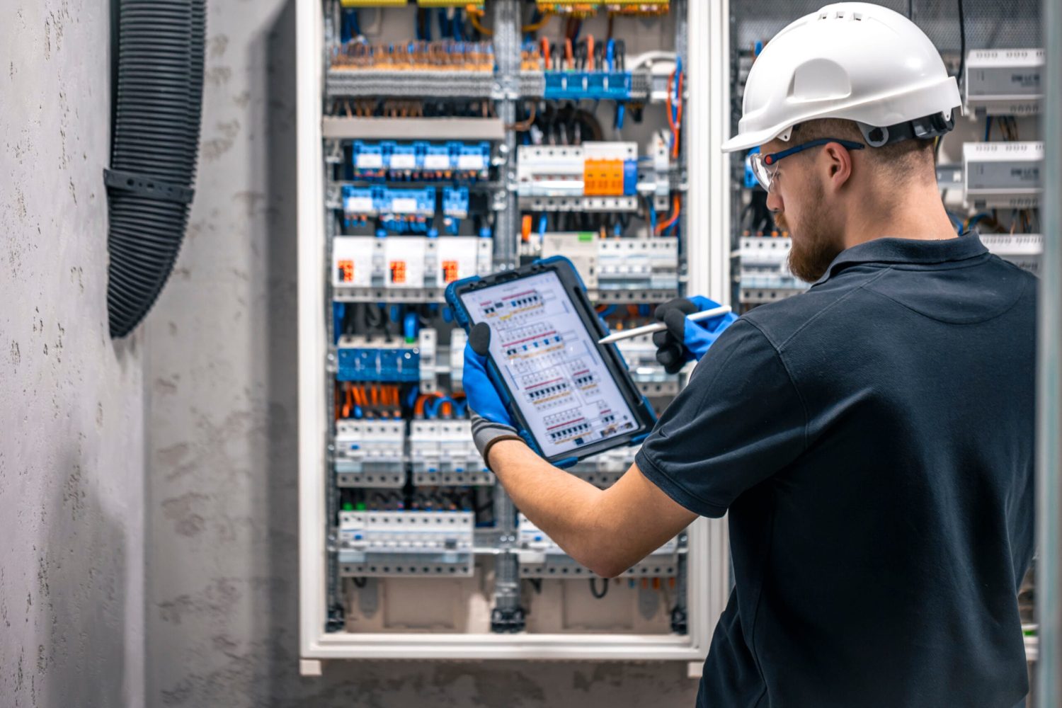 Electrical technician working in a switchboard with fuses, uses a tablet. Electrical technician looking focused while working in a switchboard with fuses. SSUCv3H4sIAAAAAAAACpySz27DIAzG75P2DhHnRkpC86+vUu3gAGlQKVRAOk1V330Gkopdd4gU/2x/9hfn+flRFGQCJxk5Fc8QYSyVWp234KXRiKvDxq3QXNicPCztqhyAzCPBpTdWgsrhBJ4tGm4CoV6VCvgVk8R58KsTLuyyIQZeXFAjwbdEWvic4mJPxCR2YIqQQ8bcOkW2oyT+r8708vU2fBGa/cSFMyNWKAHJyDmVkuu3F/aWW4OVS5O5ehgGKhTQTAnkHSz86btbyaS+ZMT4Jd5lV2Jm1d6Grd5miDLmDpMKX33GMWLnCziH5Xzn2WyGf4G5ZXO08dHTpko4HieENaVt1/QUn35ox76pt4J00EWiTlxnF8KYXSXPXcmwAeFNO4qO9+VQNUN57LqpHNg4lseZHueqrce5pniL1y8AAAD//wMASQxA3rkCAAA=